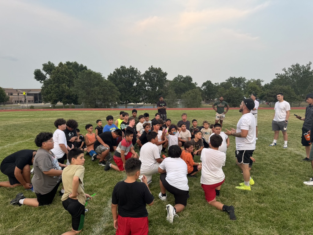 Coach Eli talking to the Bear Creek 61 team, all on a knee